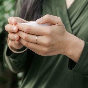 Woman wearing 14k gold filled thick sparkle ring and various other Laurel Elaine Jewelry