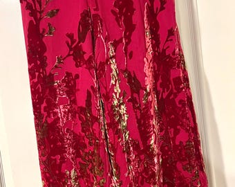 Può includere: Pantaloni a gamba larga in un vivace rosa fucsia con un motivo floreale in velluto in rilievo in una tonalità di rosa più scura. I pantaloni presentano un elastico in vita con coulisse abbinata e una silhouette ampia e fluida.