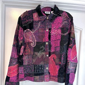May include: A patchwork jacket in shades of pink, purple, and black, featuring paisley and floral embroidery. The jacket has a button-up front and a velvet collar. The brand label "Chico's" is visible.