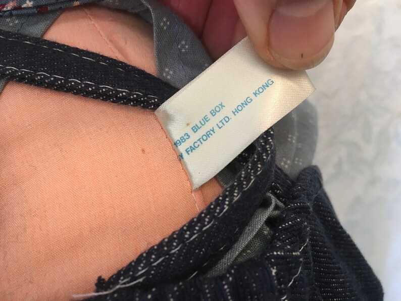 Puede incluir: Una etiqueta blanca con texto azul que dice "1983 BLUE BOX  FACTORY LTD. HONG KONG".