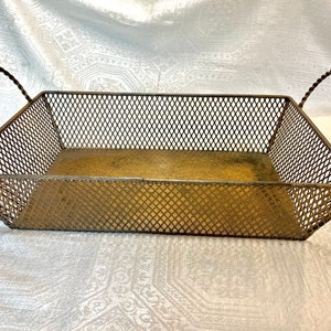 May include: A gold-toned metal wire basket with two handles. The basket has a diamond-shaped wire mesh pattern.