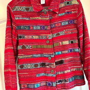 May include: Red, blue, and green striped jacket with a button closure. The jacket is made of a textured fabric and has a collar. The label on the jacket reads "Coldwater Creek".