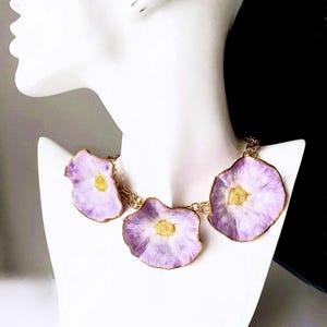 Collar de flores en blanco, lila, morado y dorado