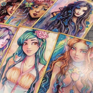 May include: A set of colorful watercolor paintings featuring female figures with flowing hair and intricate details. Each painting is framed with a gold border and has a unique theme, including nature, fantasy, and underwater scenes.