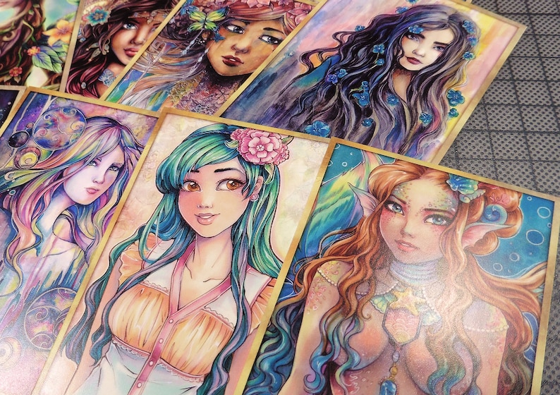 May include: A set of colorful watercolor paintings featuring female figures with flowing hair and intricate details. Each painting is framed with a gold border and has a unique theme, including nature, fantasy, and underwater scenes.