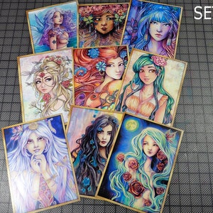 May include: Set of eight illustrated cards featuring colorful portraits of women with floral accents. The cards are framed with a gold border and have a textured surface. The cards are labeled "SET A" in the top right corner.