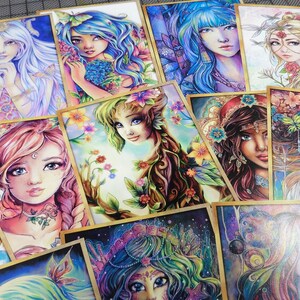 May include: A collection of colorful illustrated cards featuring female figures with floral and nature-inspired designs. Each card has a unique design with intricate details and vibrant colors.
