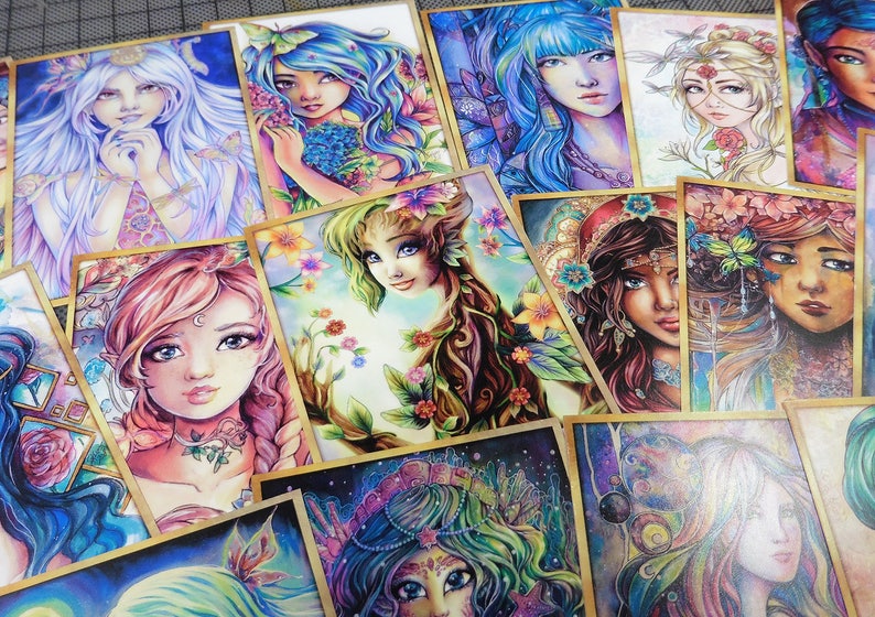 May include: A collection of colorful illustrated cards featuring female figures with floral and nature-inspired designs. Each card has a unique design with intricate details and vibrant colors.