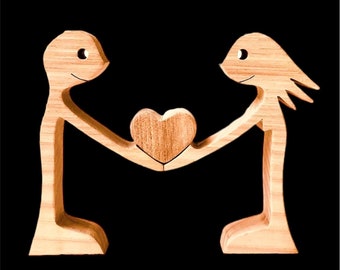 A couple standing together holding a heart