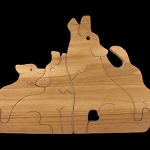 May include: Wooden puzzle featuring four animals, a cat, a dog, and two wolves. The puzzle pieces fit together to form a larger image.
