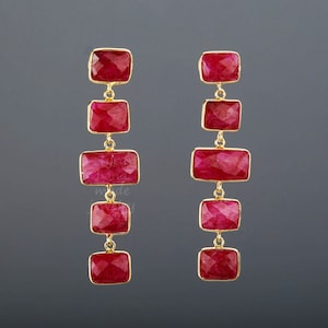 Puede incluir: Un par de pendientes largos y colgantes con m&uacute;ltiples gotas de piedras preciosas rojas. Cada pendiente tiene seis piedras preciosas rojas rectangulares conectadas por eslabones de oro.