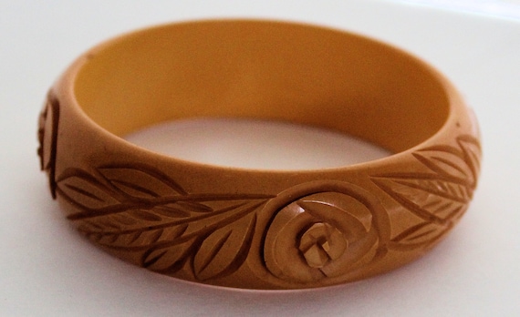 Sold at Auction: Three deeply carved Bakelite bangle bracelets in shades of  orange with flower and leaf motifs. 2 1/2