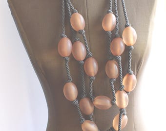 Collar de Giorgio Armani con llamativo cordón de seda gris y cuentas de lucita color miel.