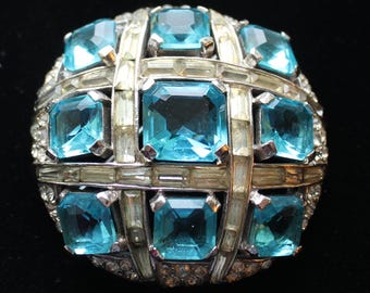 Pin con botón "Tablero de ajedrez" de la colección "Joyas de la Fantasía" de MB BOUCHER, color aguamarina y baguettes transparentes.