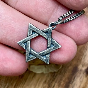 May include: A silver Star of David pendant necklace with a textured finish.