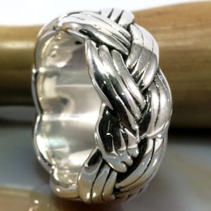 May include: A silver ring with a braided design. The ring is thick and has a polished finish.