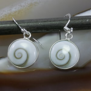 May include: A pair of silver earrings featuring a white and brown shell design. The shell has a spiral pattern.