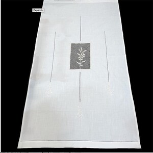Puede incluir: Toalla de cocina de lino blanco con diseños florales bordados. La toalla tiene forma rectangular y presenta un motivo floral central con fondo negro. La palabra "Expandir" es visible en la esquina superior izquierda.