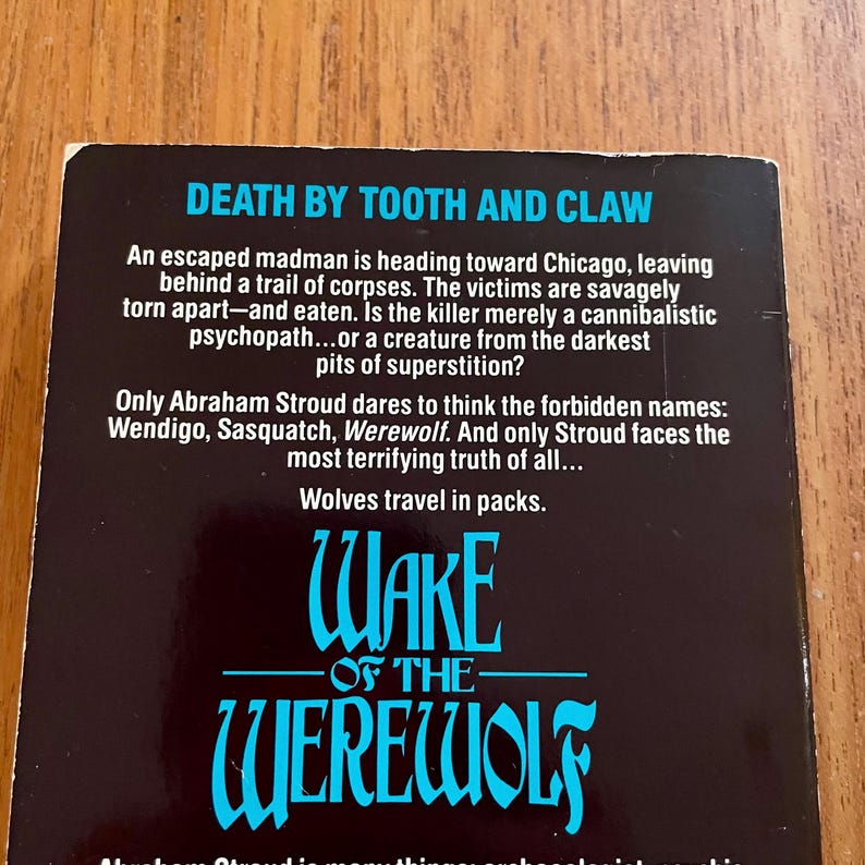 May include: A book cover with the title "Death by Tooth and Claw" in white text on a black background. Below, the title "Wake of the Werewolf" is in blue, stylized lettering. The cover text describes a story involving a madman, corpses, and werewolves.