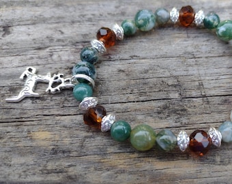 May include: A green and brown agate beaded bracelet with a silver deer charm. The bracelet is made with round beads and silver spacers.