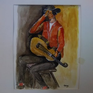 May include: A watercolor painting of a person sitting on a stool and playing a guitar. The person is wearing a red jacket and a hat. The background is a yellow and brown wash.