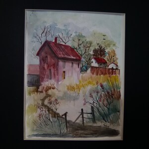 May include: Watercolor painting of a red-roofed house with a fence in front of it. The house is surrounded by trees and bushes. The painting is framed in black.