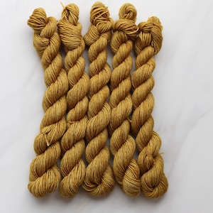 May include: Five skeins of golden yellow yarn, arranged in a row, ready for knitting or crocheting.