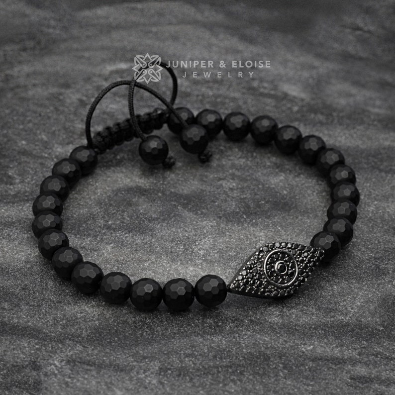 Simple yet elegant evil eye bracelet made with 6mm faceted onyx beads and a 925 silver evil eye charm, accented with black zircon stones. Adjustable macrame knot for easy wear