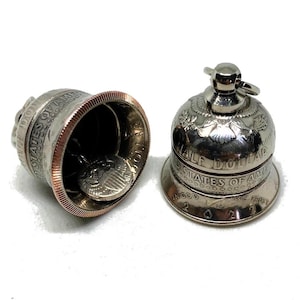 May include: Two silver bells made from half dollar coins. The bell on the left is open, showing the coin inside. The bell on the right is closed and has the inscription "Half Dollar" and "United States of America" around the rim.
