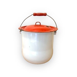 Peut inclure: Une casserole en émail blanc avec un couvercle rouge et une poignée en bois. La casserole a une poignée en fil de fer et est un article de cuisine vintage.