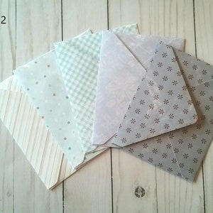 May include: Pack of six envelopes with different patterns. The envelopes are in shades of gray, white, and blue. The patterns include stripes, polka dots, gingham, and a floral design.