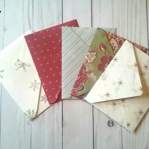 May include: Pack of 7 envelopes with various patterns. The envelopes are cream, red with white polka dots, green with floral patterns, and blue with white stripes. The envelopes are all folded and stacked on top of each other.