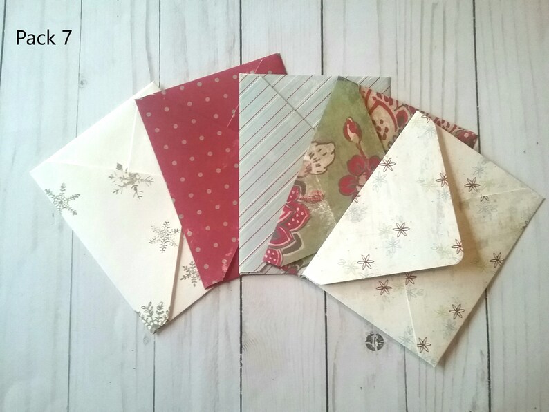May include: Pack of 7 envelopes with various patterns. The envelopes are cream, red with white polka dots, green with floral patterns, and blue with white stripes. The envelopes are all folded and stacked on top of each other.
