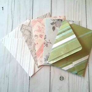 May include: Pack of six patterned envelopes in various colors and designs, including stripes, floral, and paisley. The envelopes are arranged in a fan shape on a white wooden surface. The text "Pack 1" is visible in the top left corner of the image.