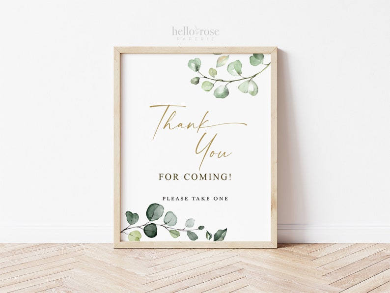 May include: A white sign with a gold "Thank You for Coming!" message and green watercolor eucalyptus leaves. The sign says "Please take one" at the bottom.