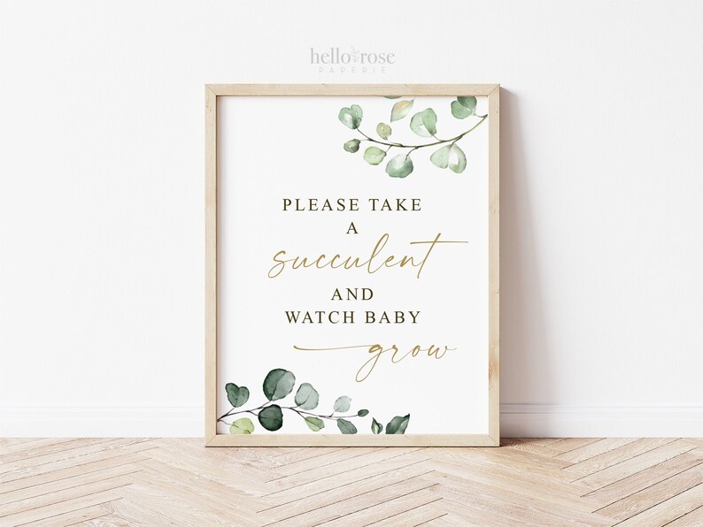 May include: A white sign with a gold frame and green watercolor leaves. The sign says "Please take a succulent and watch baby grow."
