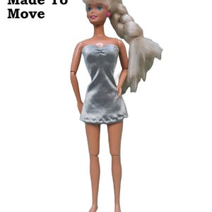May include: A silver strapless mini dress.  The fabric is a satin finish charmeuse spandex modeled on a made to move doll.