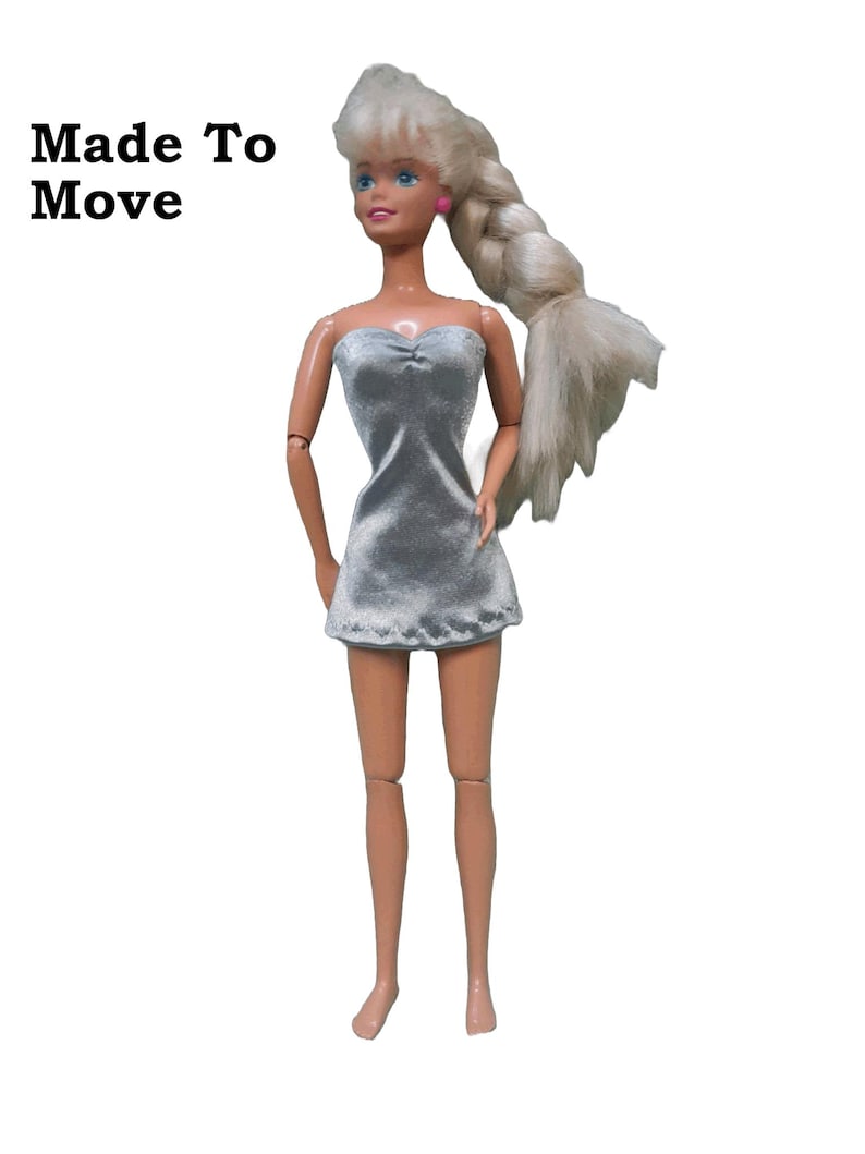 May include: A silver strapless mini dress.  The fabric is a satin finish charmeuse spandex modeled on a made to move doll.