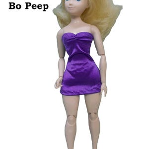 May include: Bo Peep doll with blonde hair wearing a purple strapless dress made from satin finish charmeuse spandex.