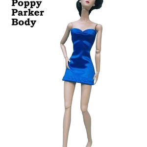 May include: A doll wearing a blue strapless satin finish spandex mini dress