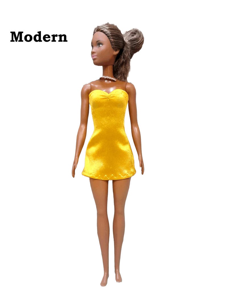 May include: A doll wearing a yellow strapless dress made from satin finish charmeuse spandex.