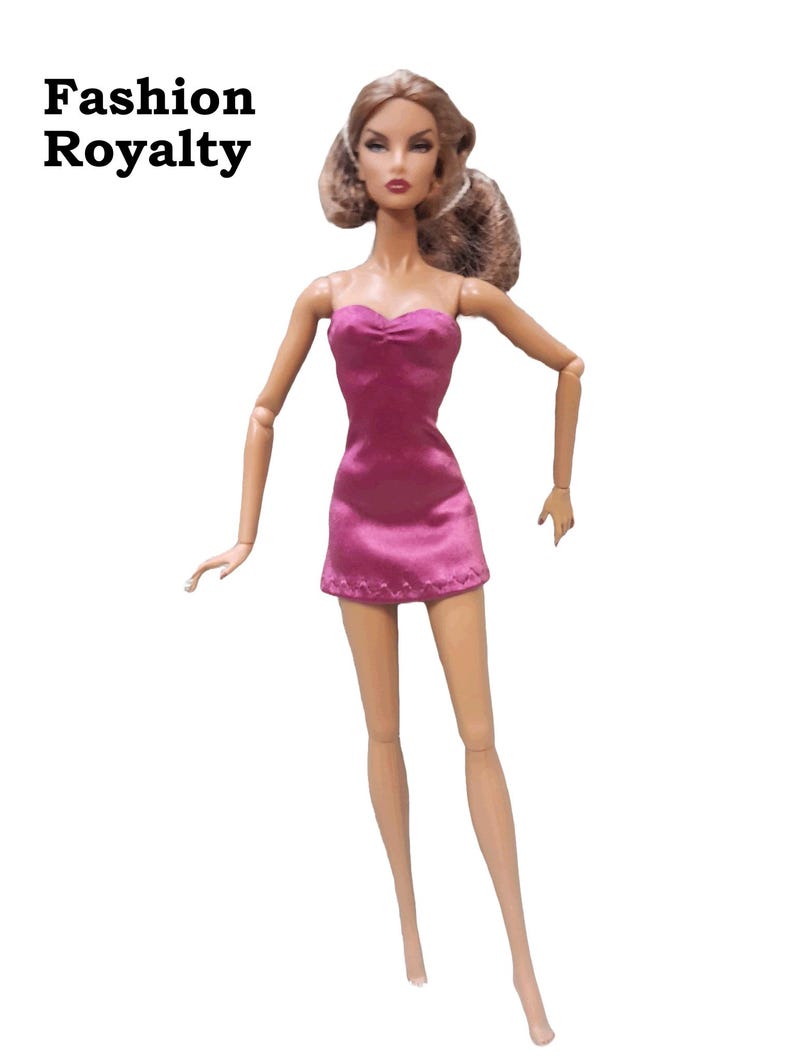 A pink strapless mini dress on a Fashion Royalty doll.  The dress features a fitted bodice with a gather at the bust and a short skirt. The dress has a satin finish and a subtle sheen.