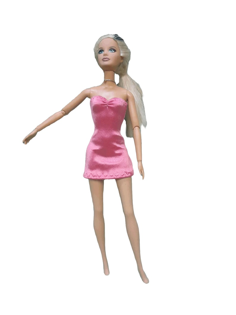 May include: A blonde doll wearing a pink strapless dress made from satin finish charmeuse spandex.