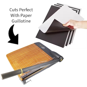 May include: A paper guillotine with a wooden base and a black handle, next to a stack of black and white paper. The text "Cuts Perfect With Paper Guillotine" is displayed.