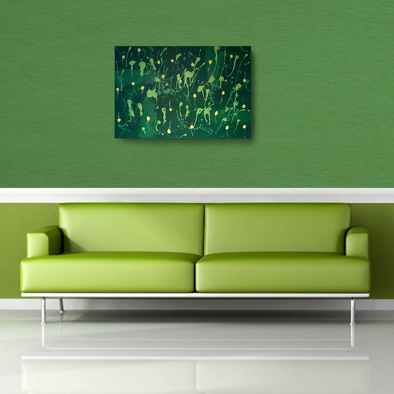 May include: Abstract painting with green and gold paint splatters on a canvas. The painting is hanging on a green wall above a green sofa.
