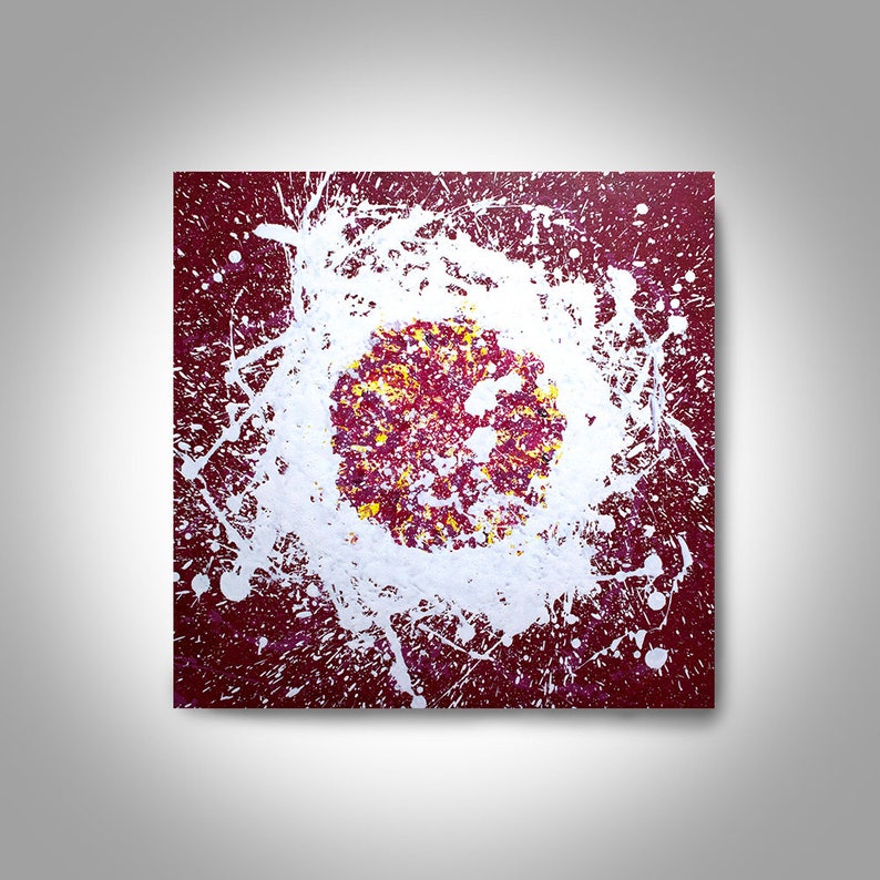 May include: Abstract painting with a white splatter pattern on a burgundy background. The centre of the painting features a circle with a yellow and red splatter pattern.