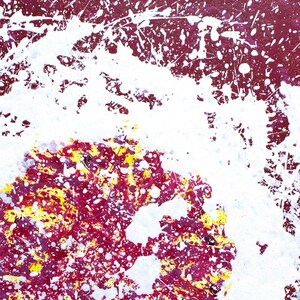 May include: Abstract painting with white, red, and yellow paint splatters on a canvas. The white paint is concentrated in the centre of the canvas, creating a circular shape.
