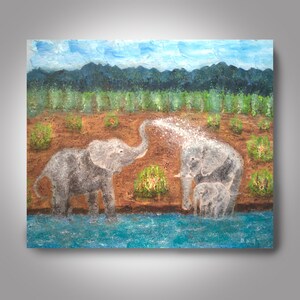May include: A painting of three elephants in a grassy field by a blue river. The elephant in the foreground is spraying water from its trunk. The elephants are gray and white.