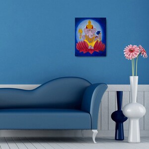 Puede incluir: Una pintura de la deidad hind&uacute; Ganesha, representada con cabeza de elefante, sentada sobre una flor de loto roja. El fondo es un c&iacute;rculo azul con un halo blanco alrededor de Ganesha.