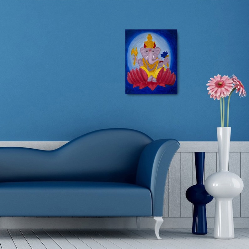 Puede incluir: Una pintura de la deidad hind&uacute; Ganesha, representada con cabeza de elefante, sentada sobre una flor de loto roja. El fondo es un c&iacute;rculo azul con un halo blanco alrededor de Ganesha.
